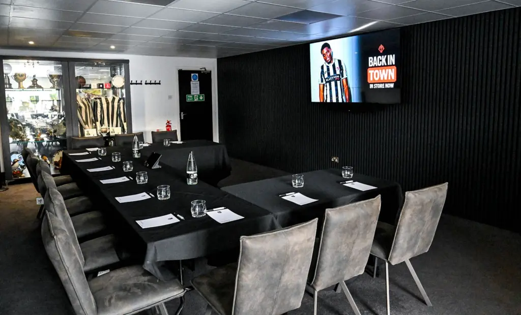 Table set up at McMenemy's Grimsby Town with GTFC merch promotions shown on the TV